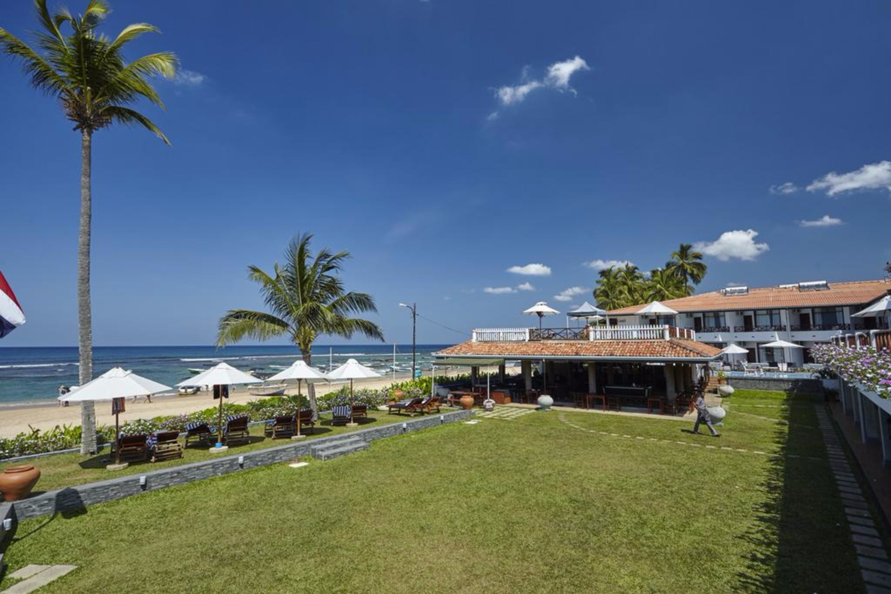Una propiedad frente a la playa con un patio, mobiliario exterior y vista al océano.
