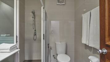 Un baño moderno con ducha acristalada, inodoro y barra para toallas.