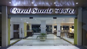 The entrance of Coral Sands Hotel with a glass facade, a reception area, and a visible indoor plant. - Coral Sands Hotel (Hikkaduwa)