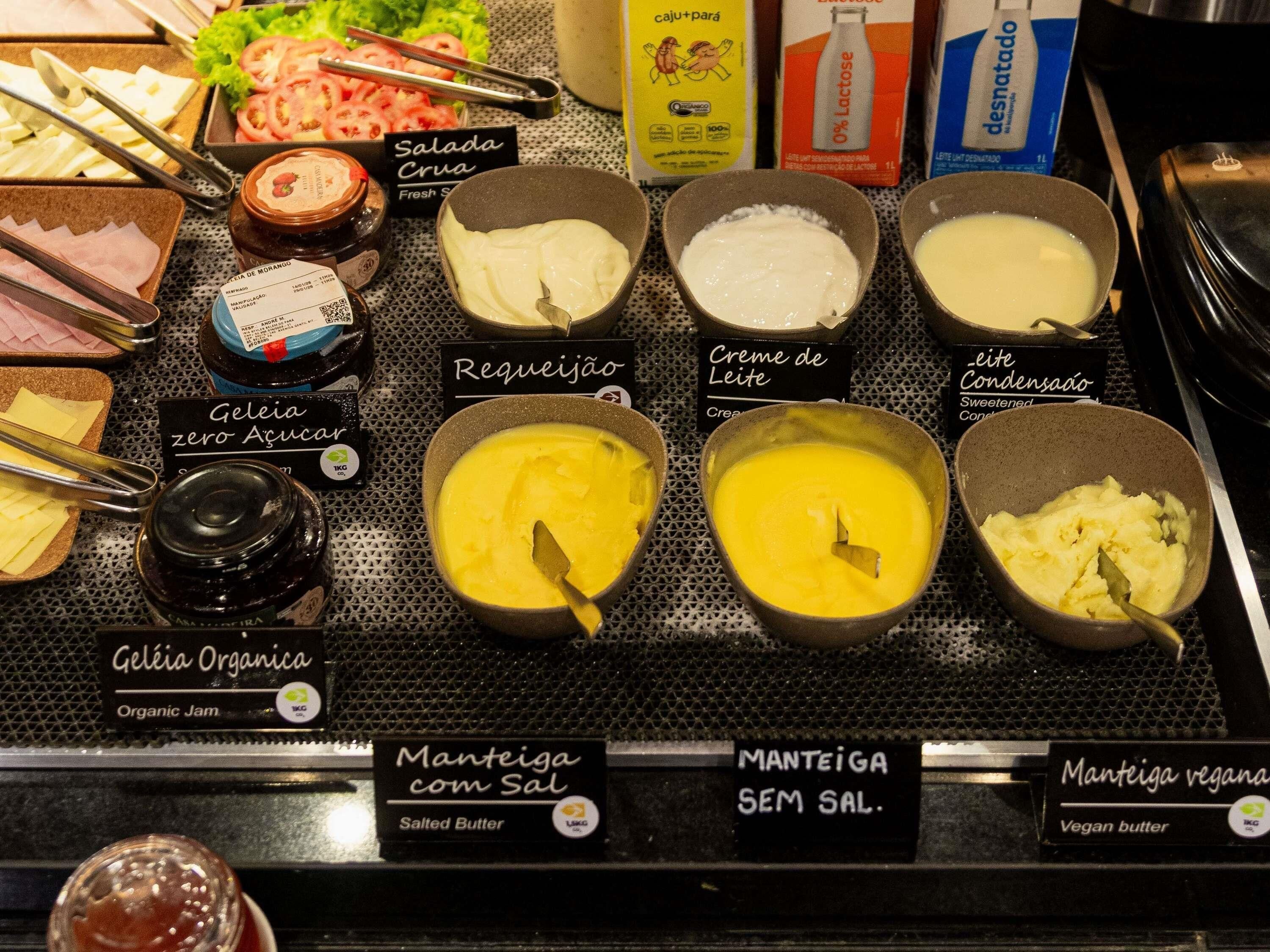 A selection of food items including fresh salads, organic jam, and various types of butter.