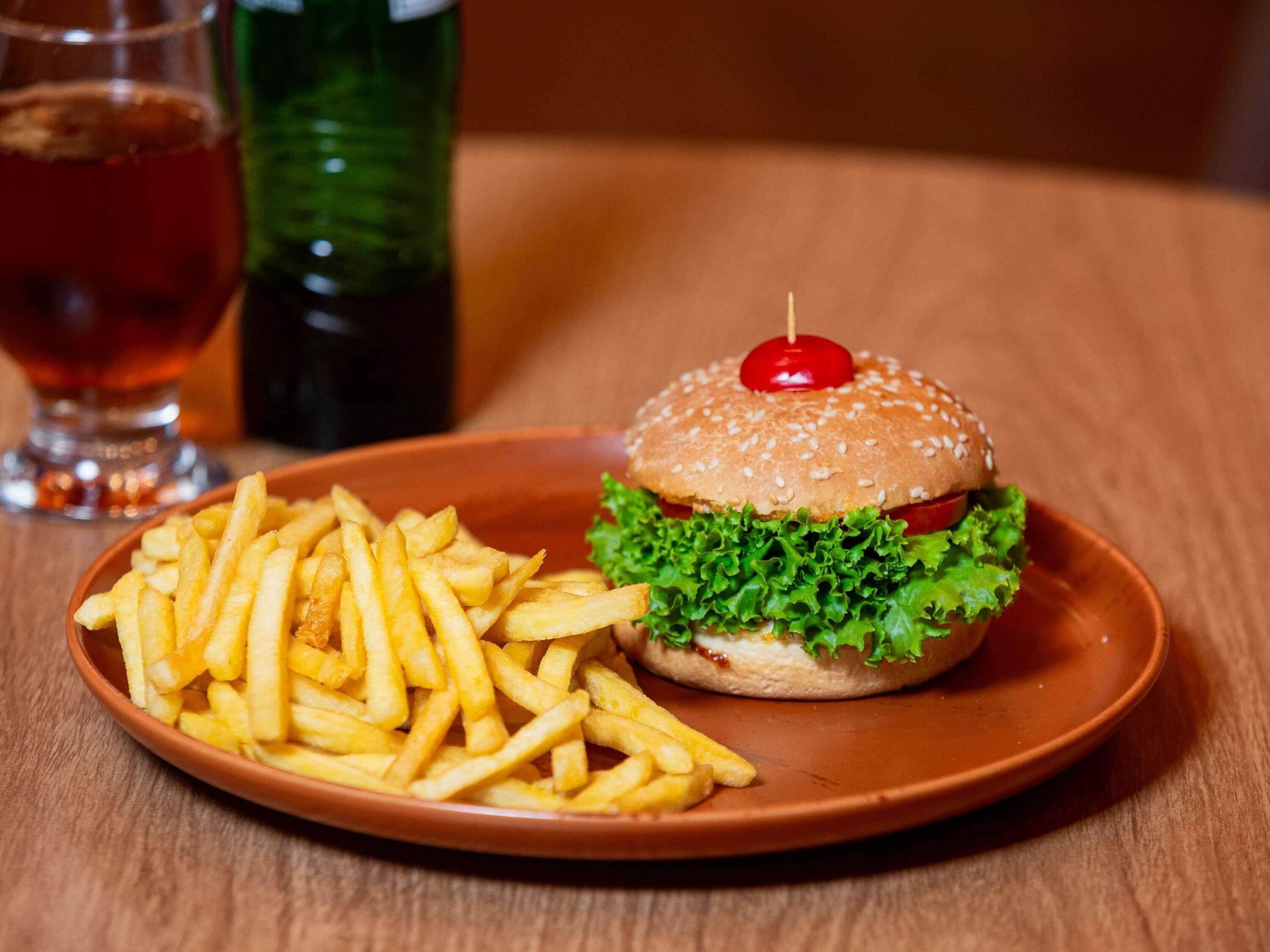 Un plato con una hamburguesa y papas fritas.