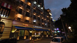 Ett hotell med flera våningar, balkonger, en restaurang och en väl synlig skylt med texten ”Colombia City Hotel”.