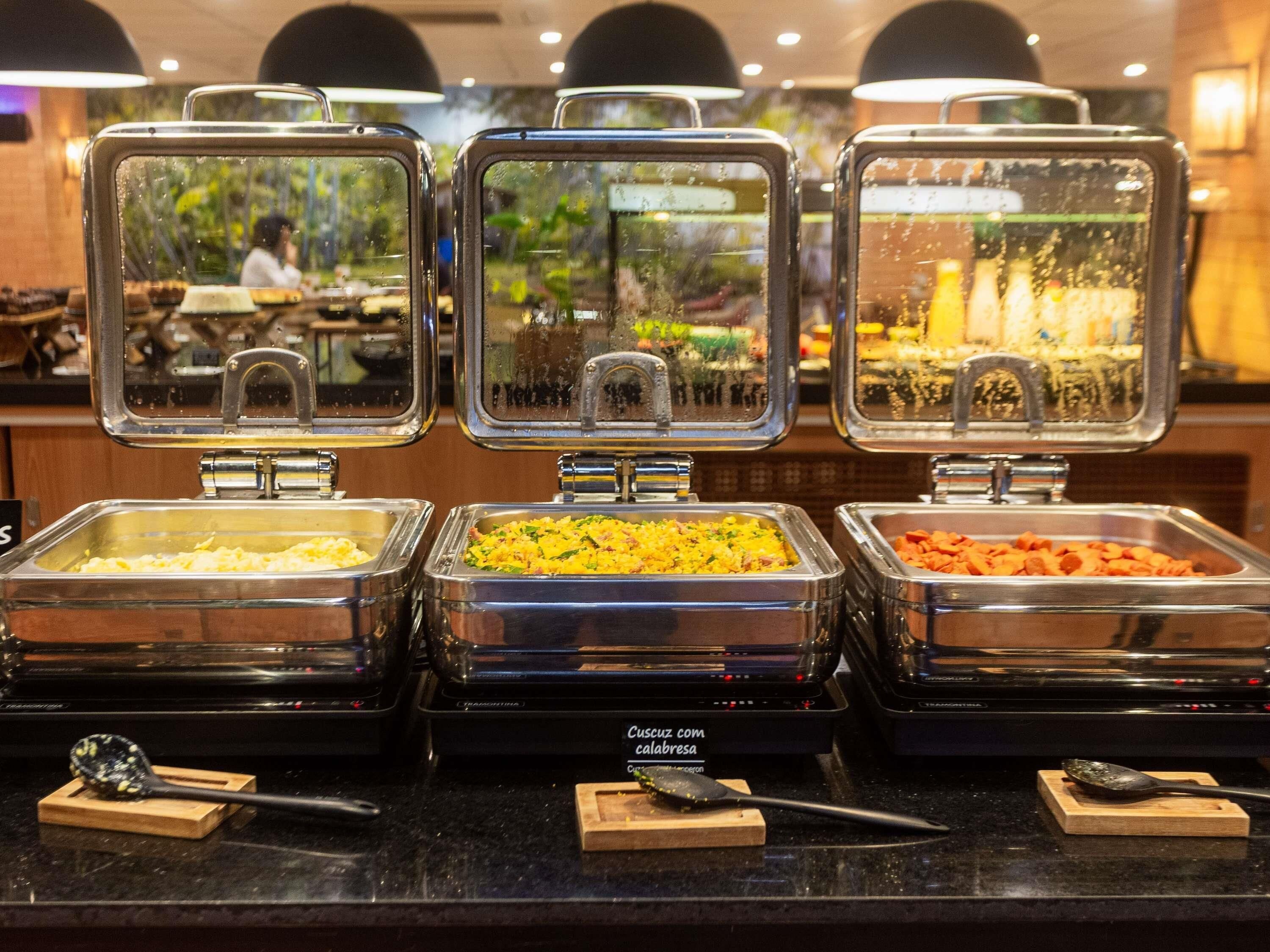 Buffet stations with various food options, each with a spoon and a small wooden board.