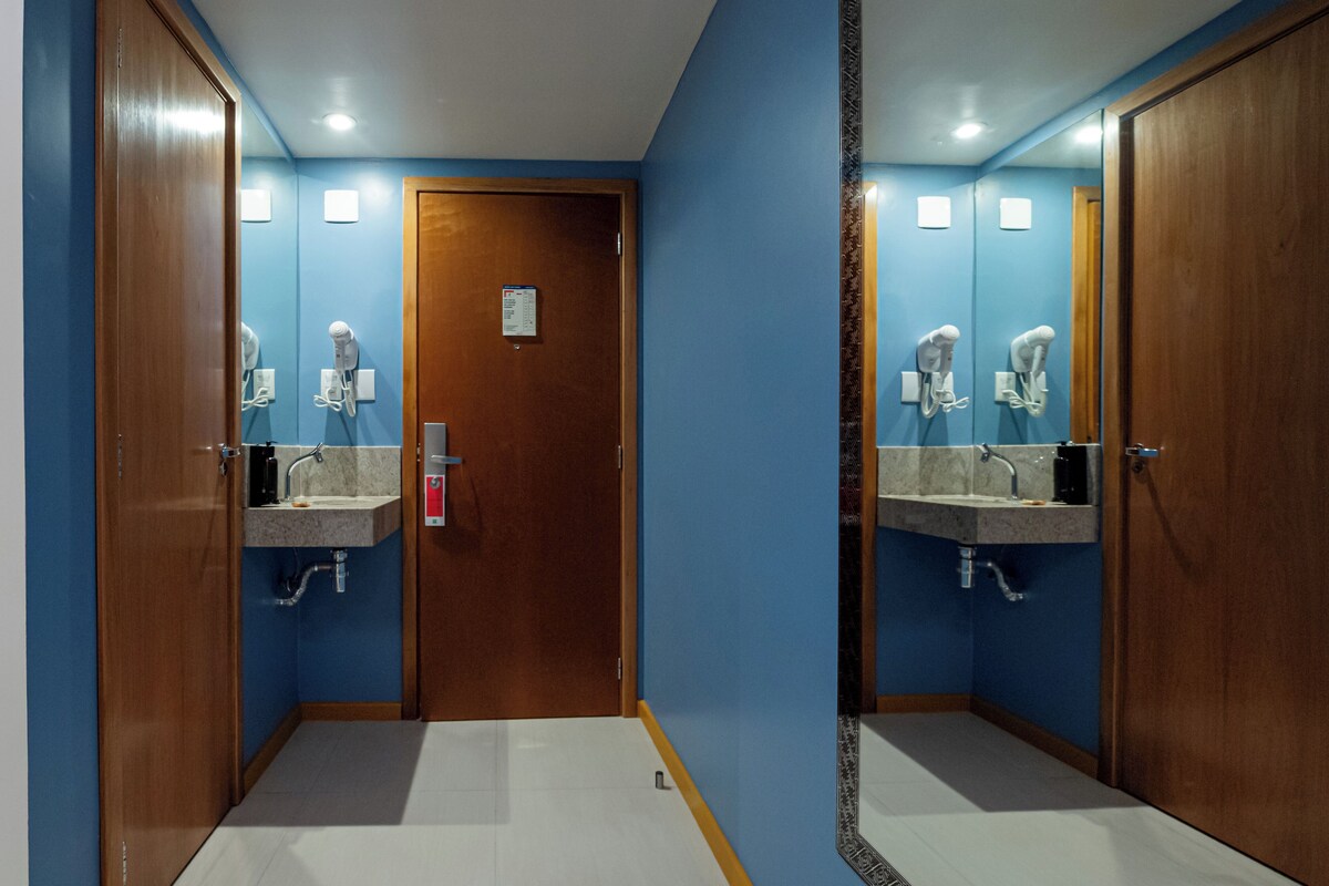 A bathroom with two sinks, a wooden door, and a mirror.