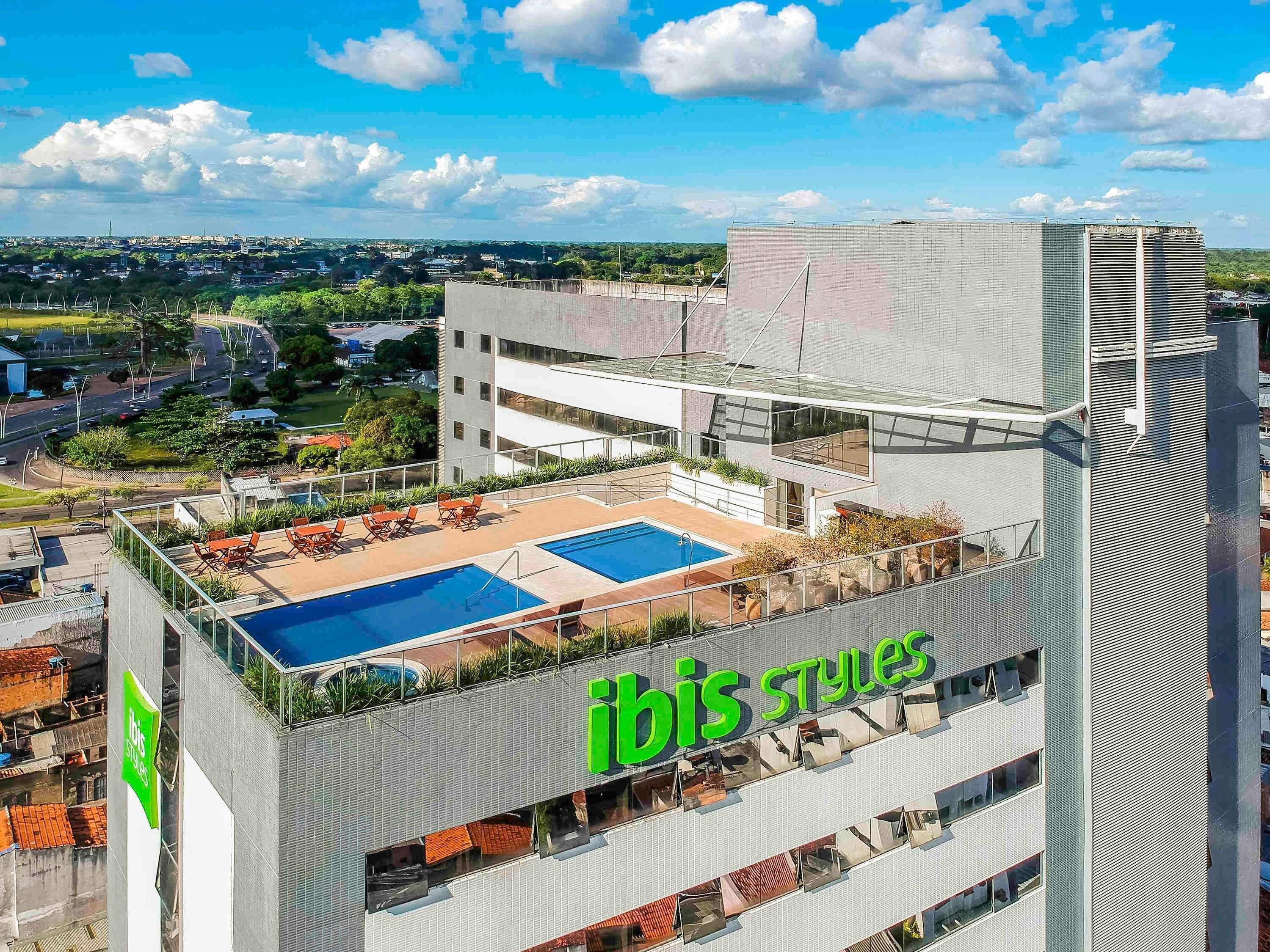 A modern building with a rooftop pool and outdoor seating area.