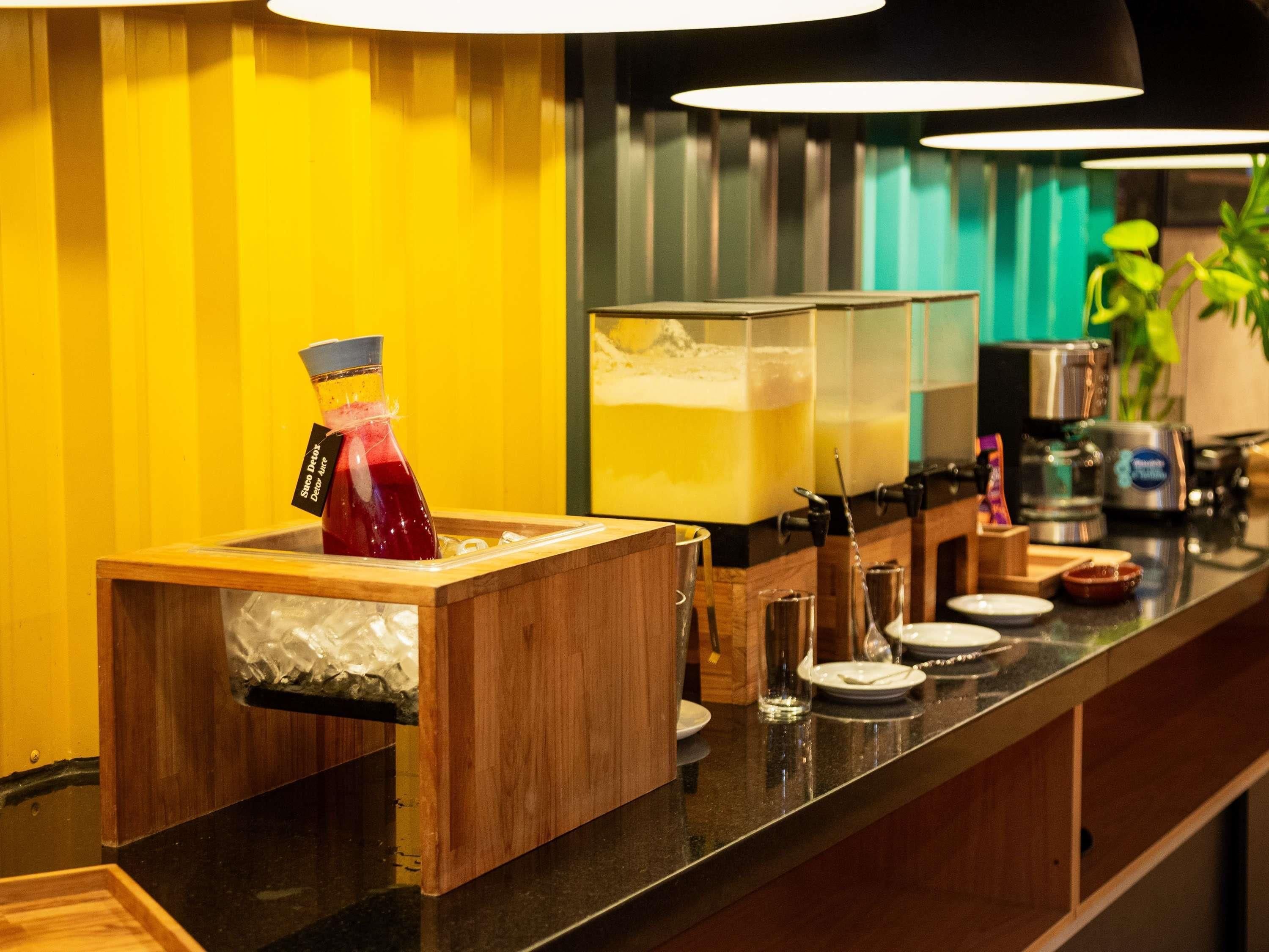 Un espace bar équipé d’un distributeur de boissons, de verres et d’une machine à café.