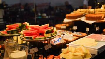 Een buffet met verschillende soorten eten en een kan melk.
