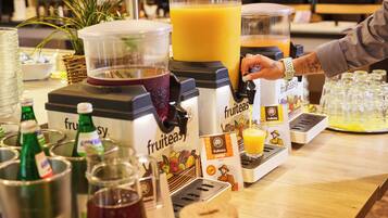 Um bar de sucos com um liquidificador, garrafas e dosadores de suco.