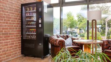 A brick wall, a vending machine, leather couches, a round table, and a lamp.
