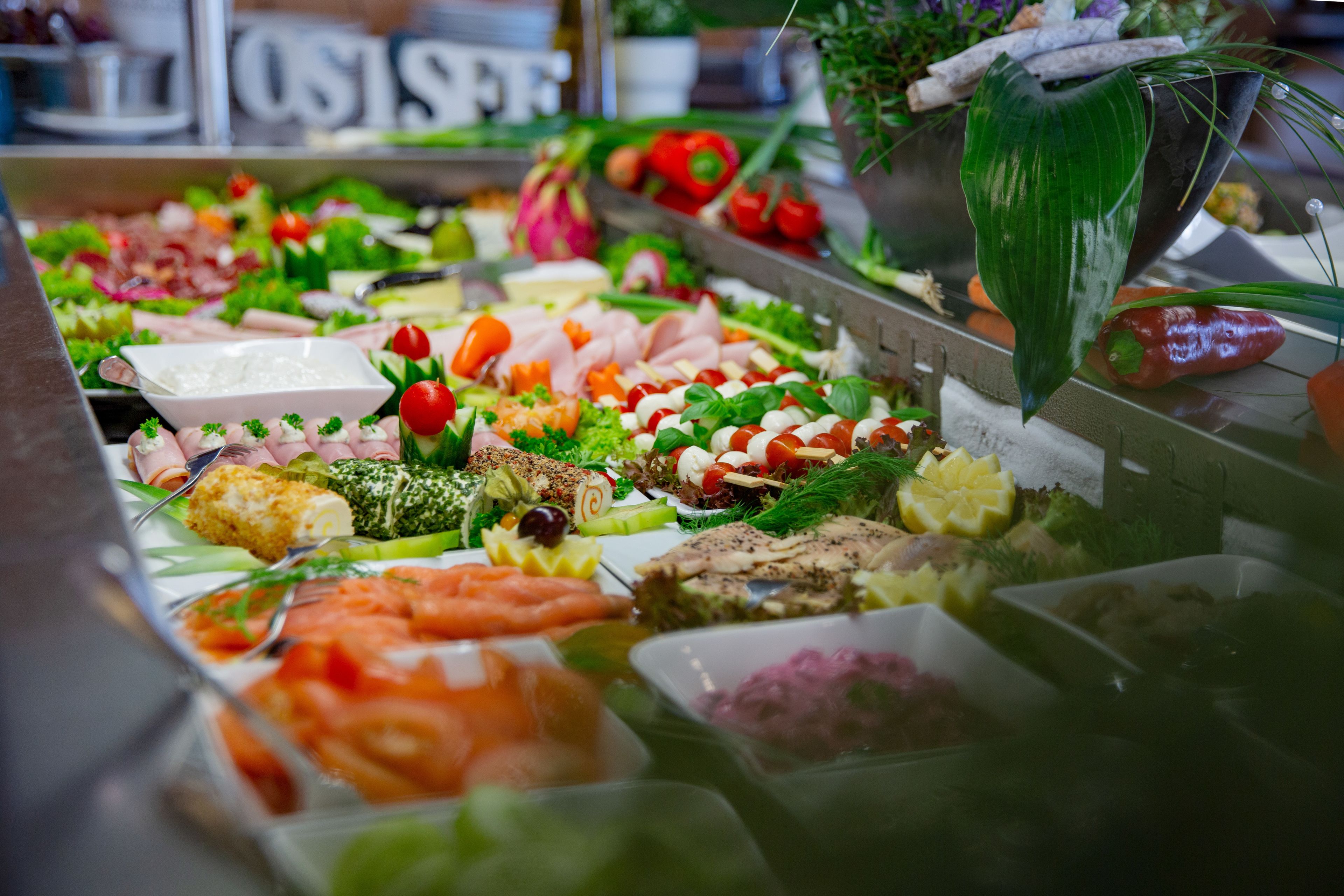 A buffet with various food items including meats, cheeses, and vegetables.
