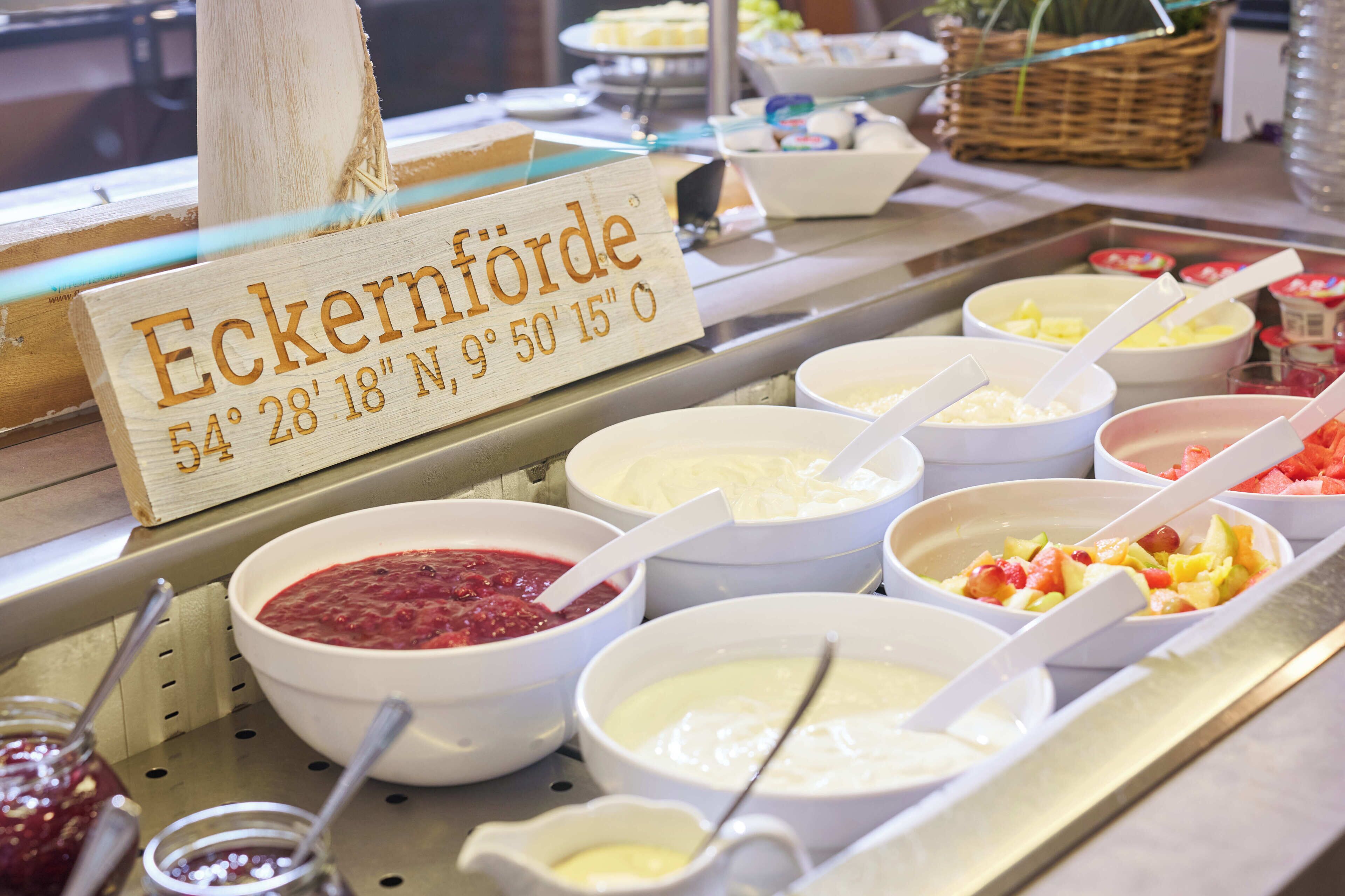 A buffet with various food items and a wooden sign indicating the size of the serving area.