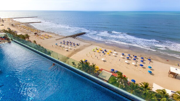 Un resort con piscina, playa y vista al océano.