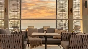 Un interior moderno con un conjunto de sofás, una mesa y vista al cielo a través de una ventana con diseño.