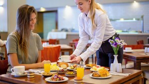 A breakfast setting with a table set for two, including plates of food, a cup of coffee, and a glass of orange juice. - Tamara Ashkelon (Ashkelon)