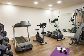 A gym with treadmills, elliptical machines, and free weights.