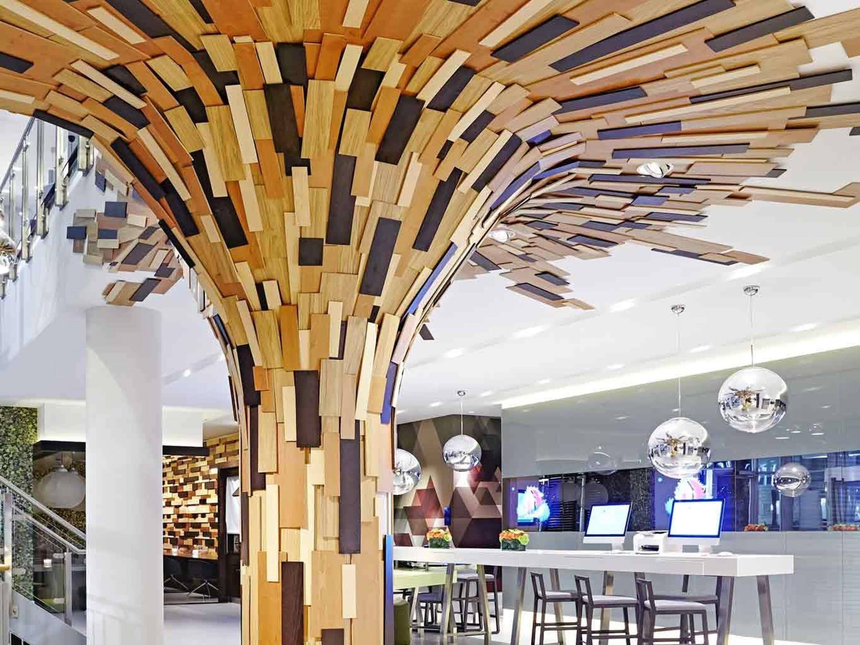 A modern interior with a wooden wall structure, a reception desk, and bar area.