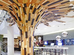Un interior moderno con estructura de pared de madera, mostrador de recepción y zona de bar.