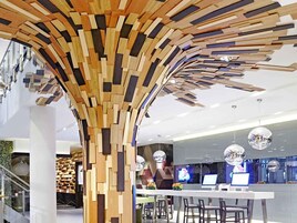 Un interior moderno con estructura de pared de madera, mostrador de recepción y zona de bar.