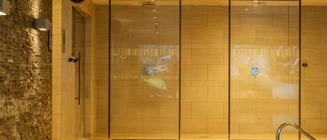 A hotel lobby with a clock, a pool area, and a wall with a textured pattern.