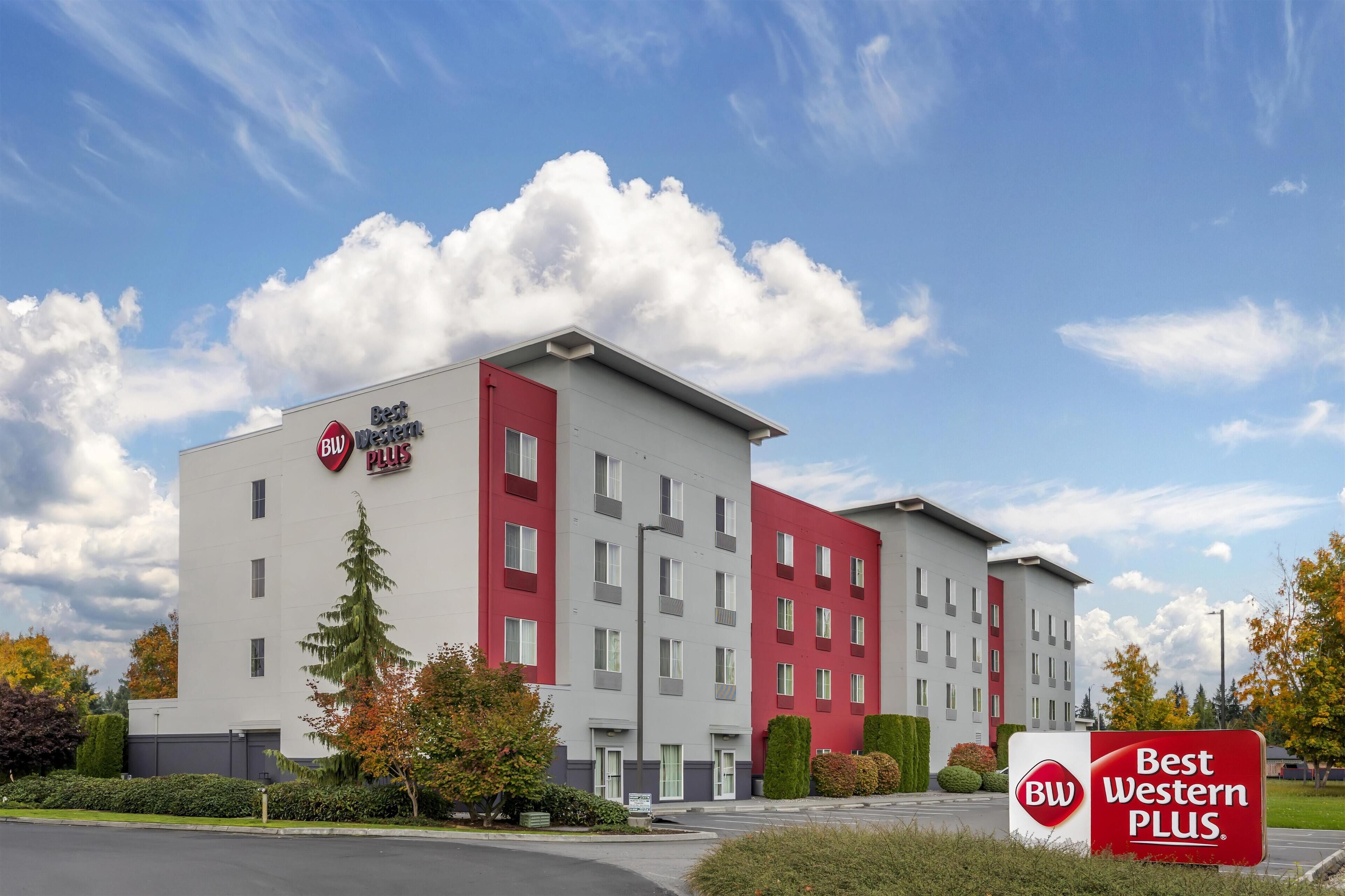 A modern hotel building with a red and white facade, labeled "Best Western PLUS."