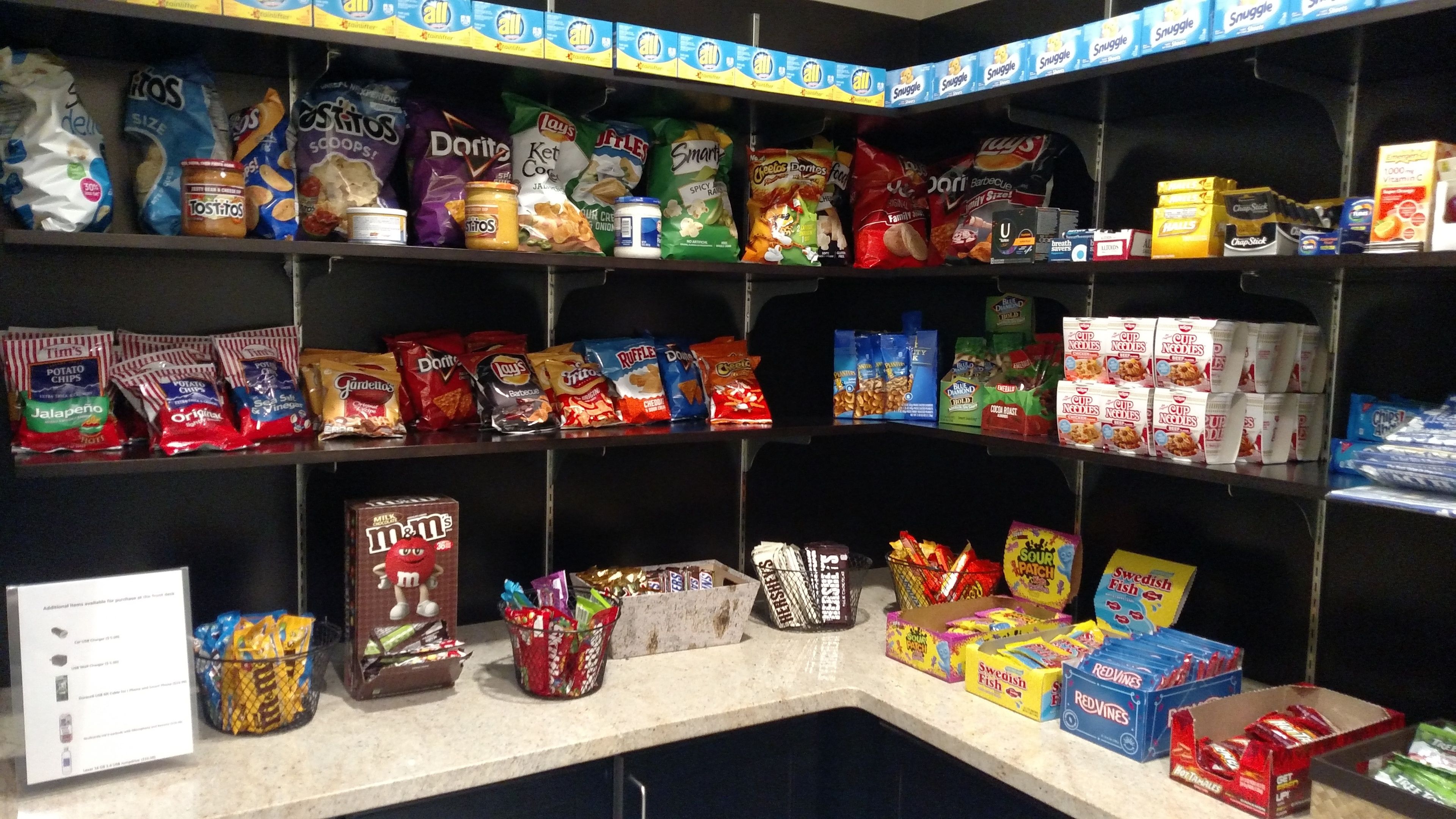 A snack display with various brands like Doritos, Lay's, and M&M's.