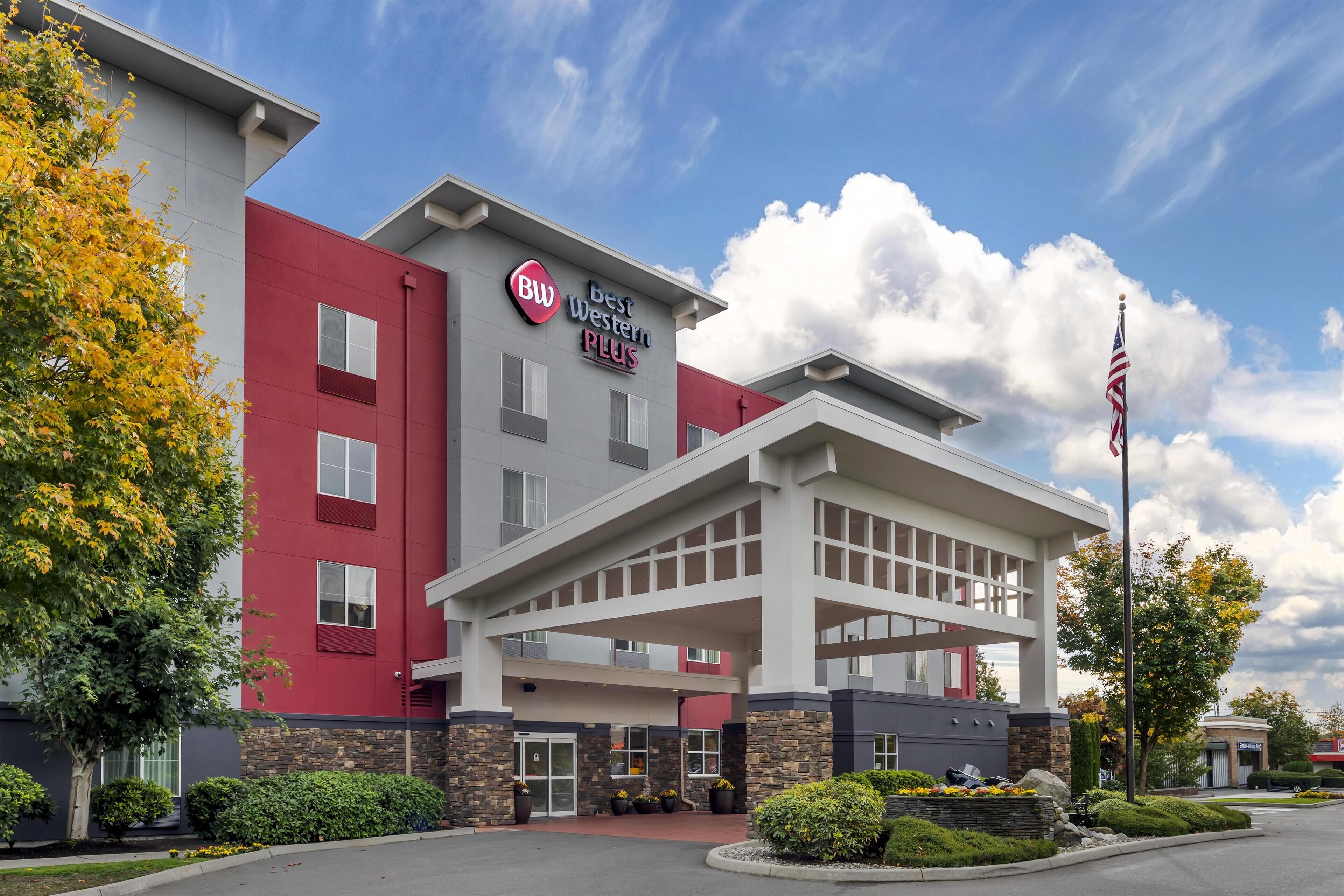 A hotel with a red and white facade, a large entrance, and an American flag.