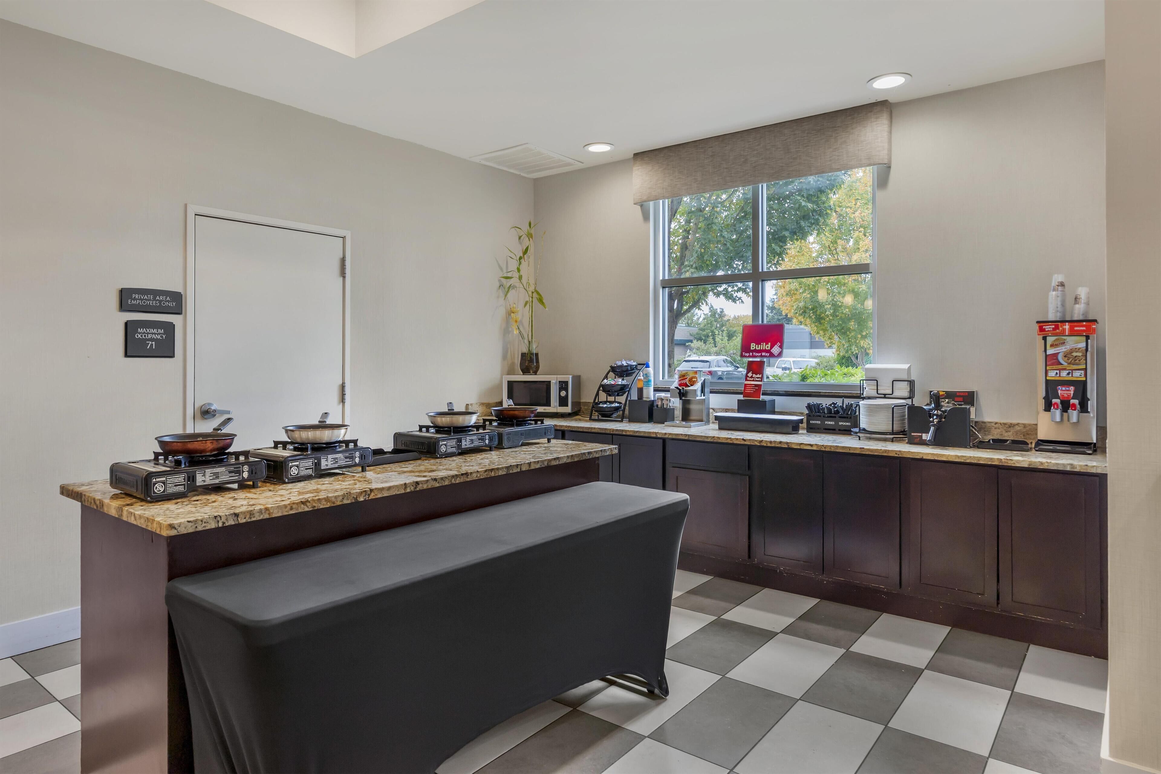 Una cocina moderna con estufa integrada, microondas y cafetera.
