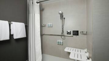 A modern shower area with a handheld showerhead, a glass shower enclosure, and a white towel rack.