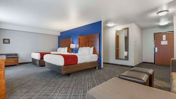 Een hotelkamer met een groot bed, twee nachtkastjes, een bureau en een stoel.