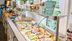 Un buffet proposant une grande variété de plats, agrémenté d’une pancarte sur laquelle on peut lire : « Baisers de sirène et baisers au bord de la mer ».