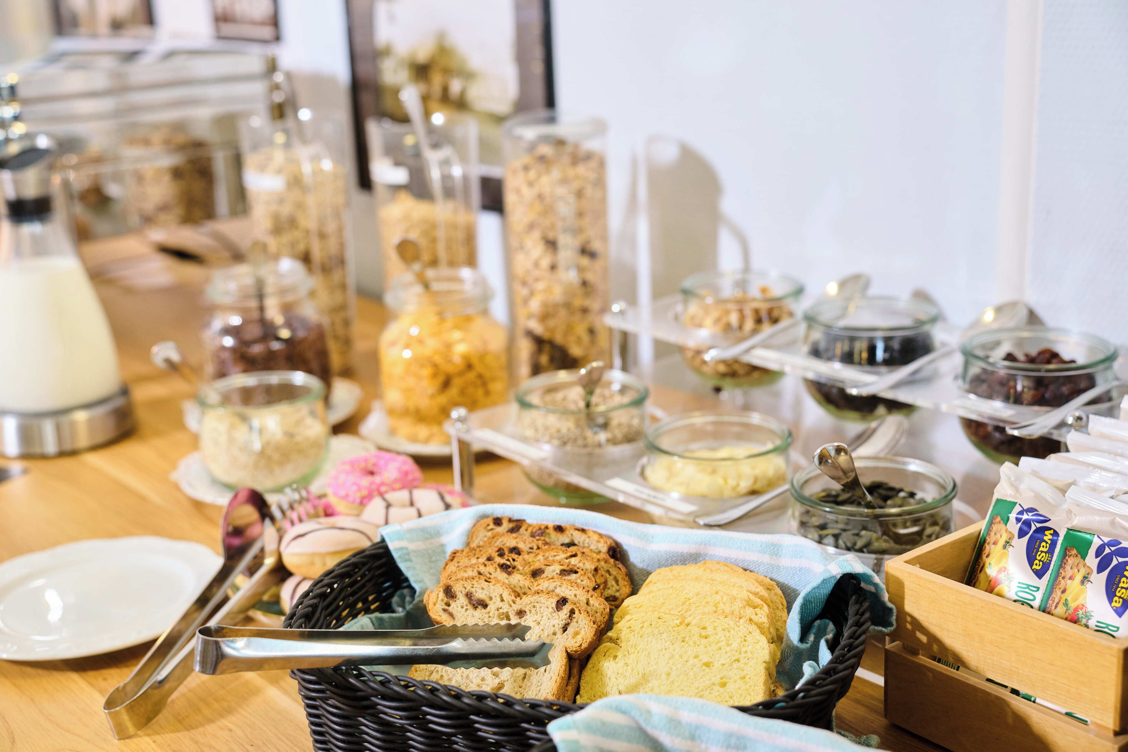 Een buffet met diverse etenswaren, zoals brood, gebak en toevoegingen.