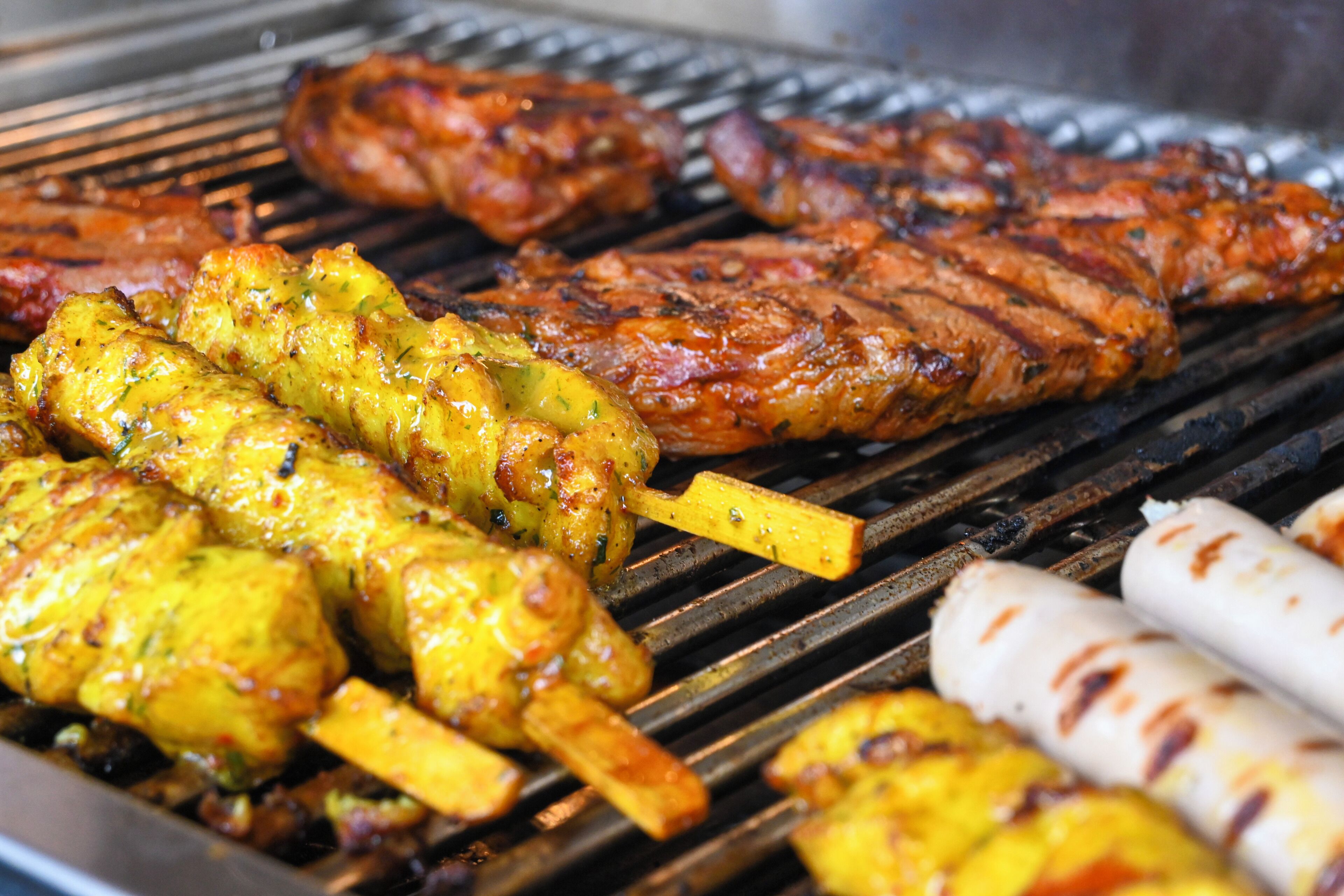 A grill with various meats and kebabs.