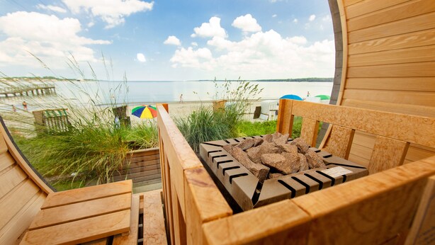 Une terrasse en bois offrant une vue sur une plage et une jetée.