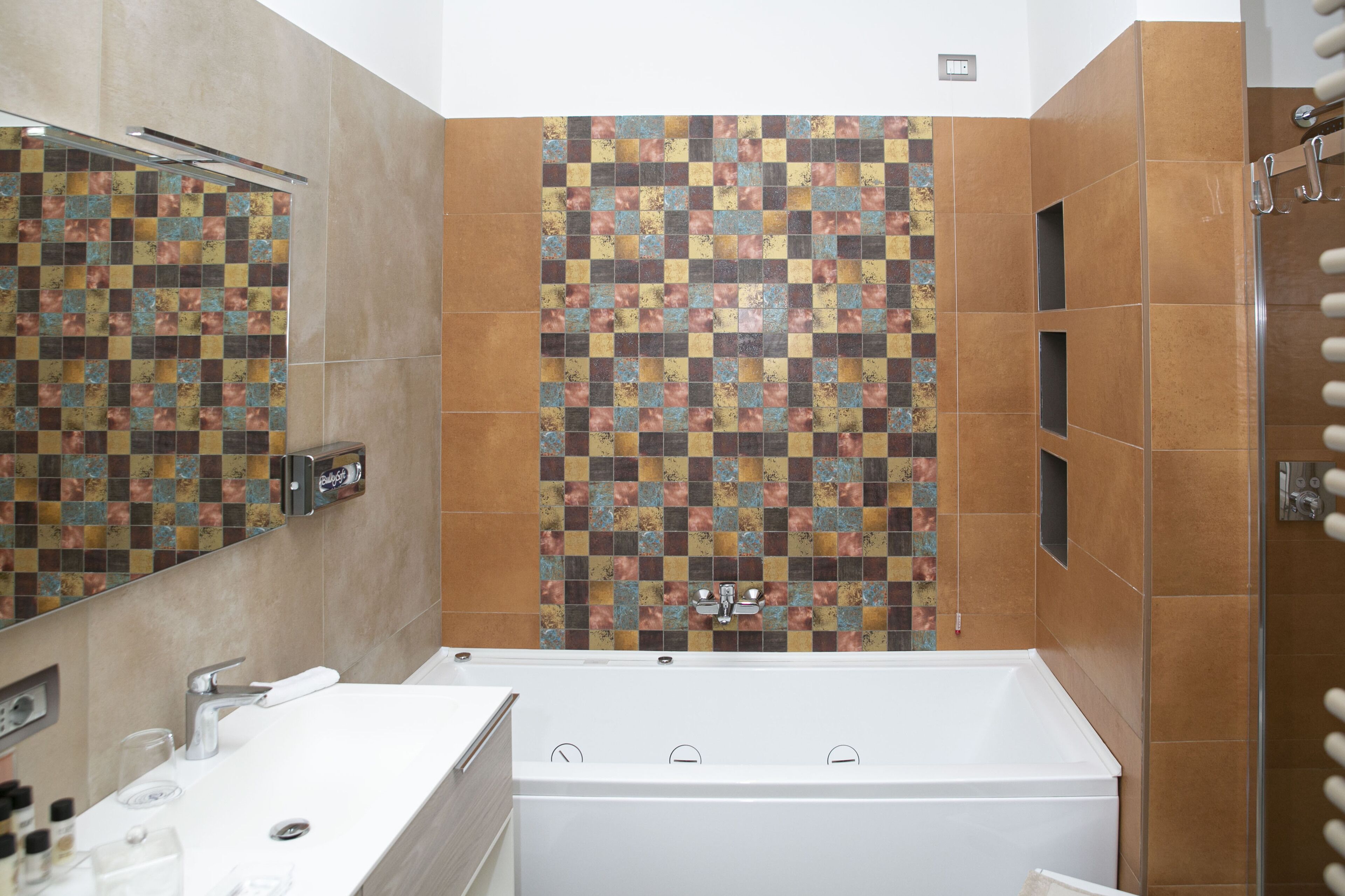 Une salle de bain avec une baignoire blanche, un lavabo avec un miroir et un espace douche.