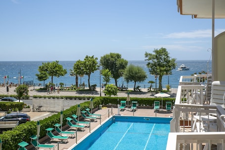 Una piscina al aire libre de temporada, sombrillas