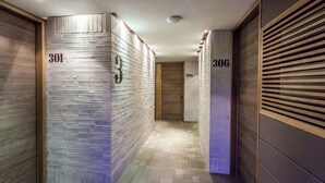 A corridor with numbered doors, wooden walls, and a patterned floor. - Mika Suites (Bogotá)