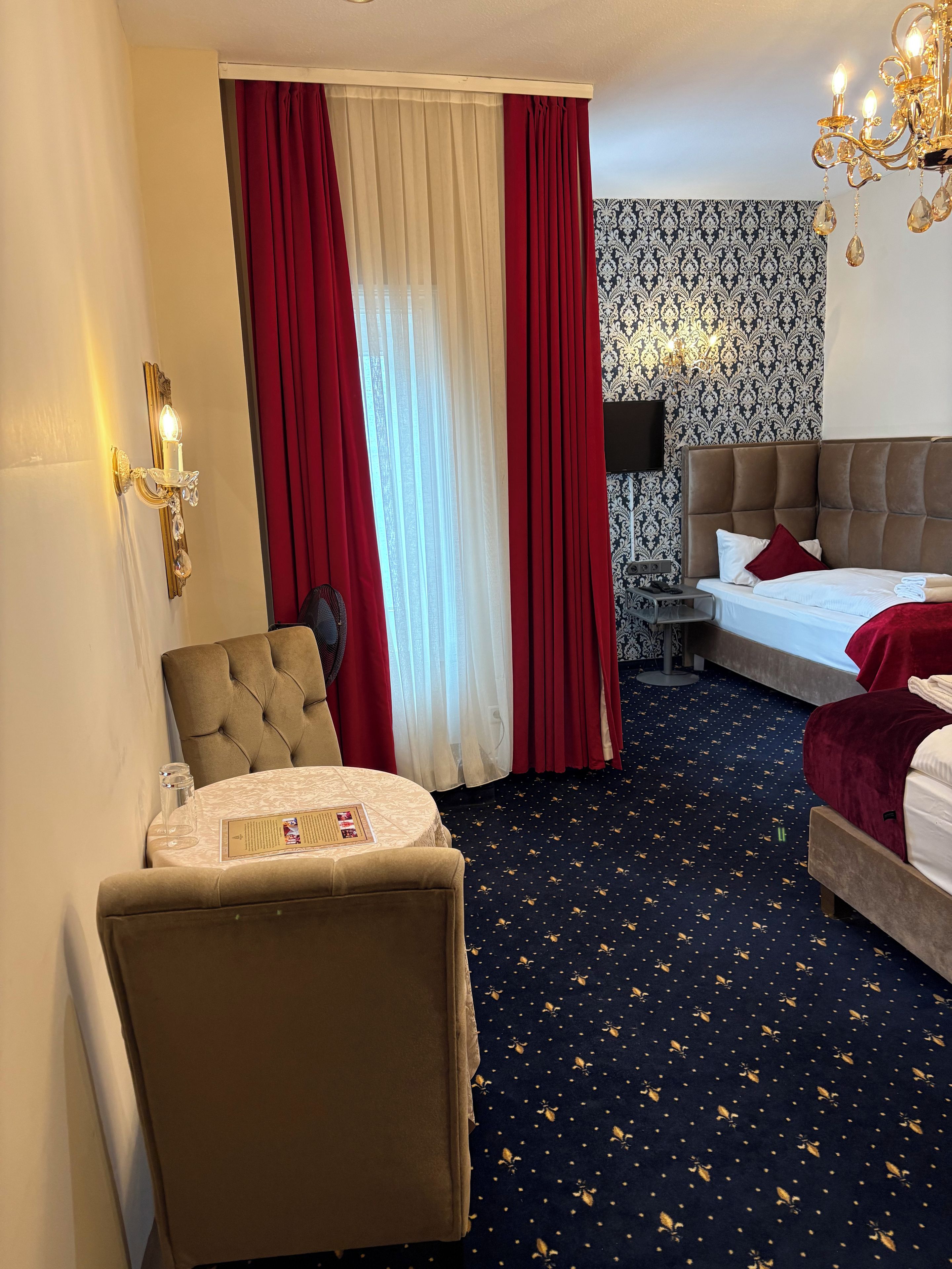 Una habitación de hotel con una cama, una silla, una mesa y un televisor de pared.