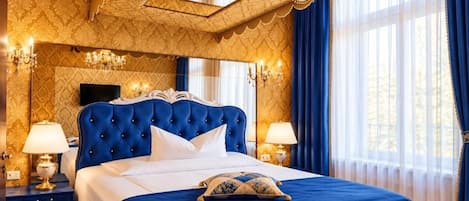 Un dormitorio lujoso con cabecera capitonada, una cama grande y un dosel.