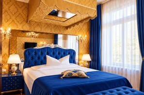 A luxurious bedroom with a tufted headboard, a large bed, and a canopy. - Hotel Village (Hamburg)