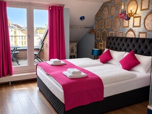 A hotel room with a bed, a balcony, and a view of buildings. - Hotel Village (Hamburg)