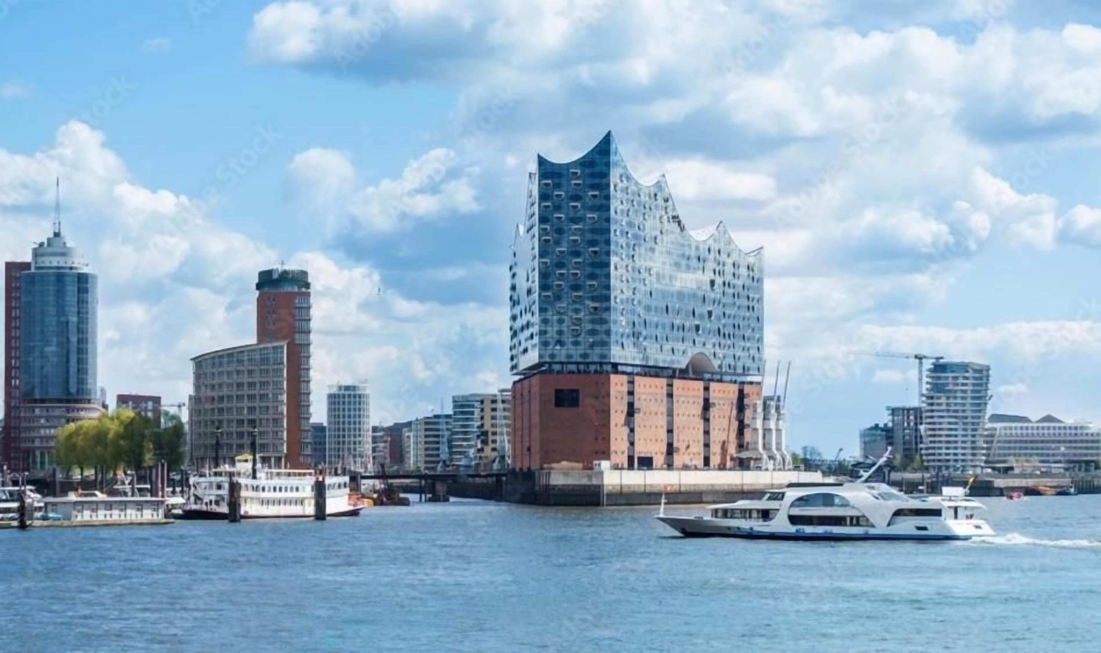 Une vue sur la ville, avec des bâtiments modernes de grande hauteur, un fleuve et un bateau, le tout situé au bord de l’eau.