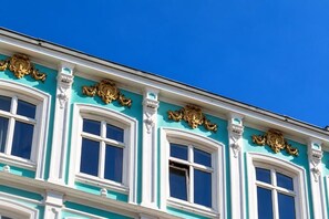 A building facade with multiple windows and ornate gold detailing. - Hotel Village (Hamburg)