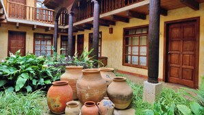 Un patio con macetas de terracota y balcones de madera.