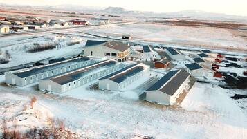 Un gran complejo industrial con varios edificios, incluyendo una estructura central con un amplio garaje y otros edificios más pequeños con techos planos.