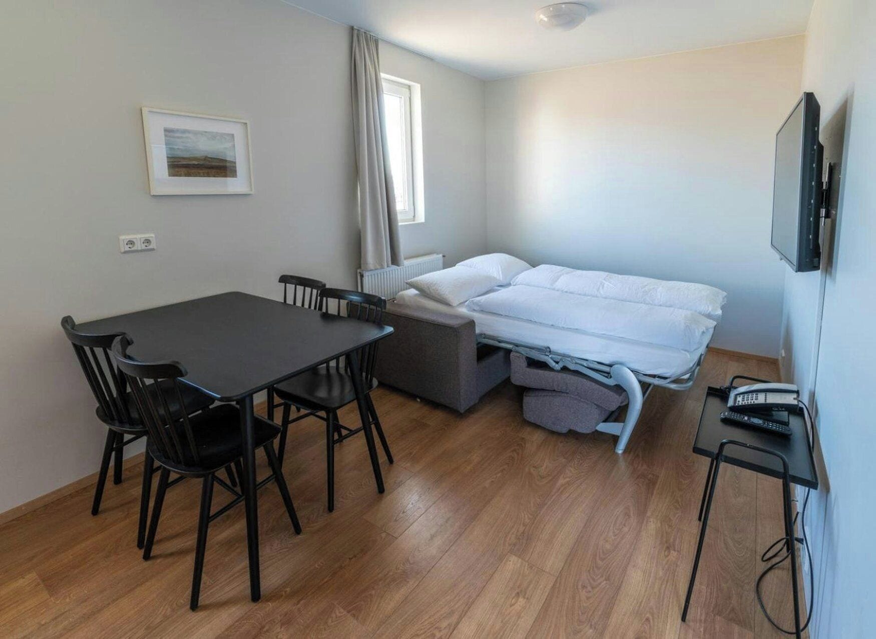 Ein gemütlicher Raum mit einem Bett, einem Tisch und Stühlen.