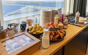 Un bufé de desayuno con diferentes alimentos, utensilios y condimentos.