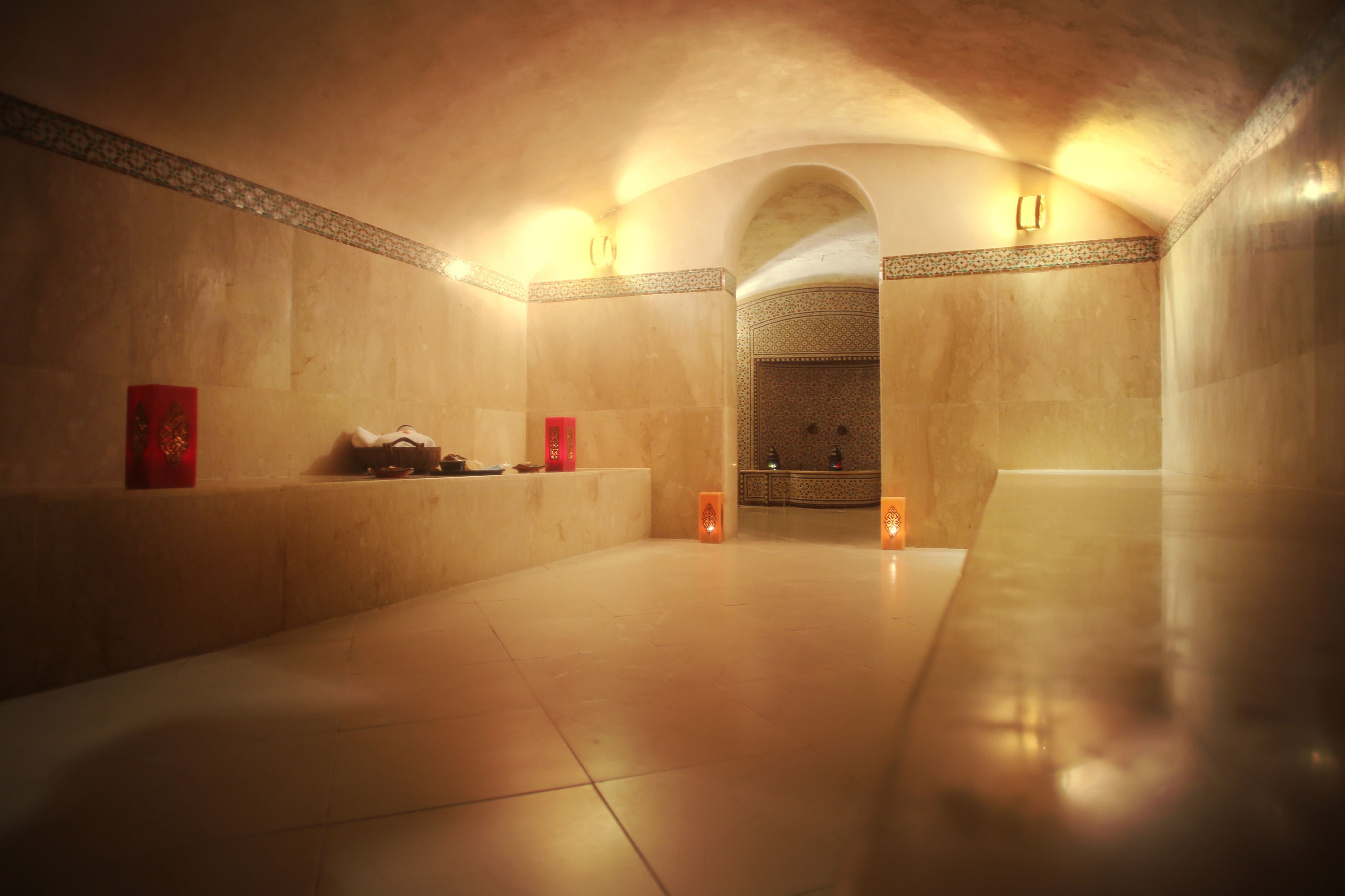 A spacious, well-lit interior with a tiled floor, a bench, and a small altar with candles.