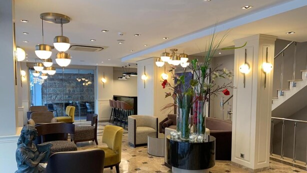 A lobby with modern furniture, a central decorative vase, and a staircase. - Regency World Suite Istanbul (Istanbul)