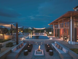 A modern outdoor lounge area with a pool, seating, and a fire feature. - Shangri-La Lhasa (Lhasa)