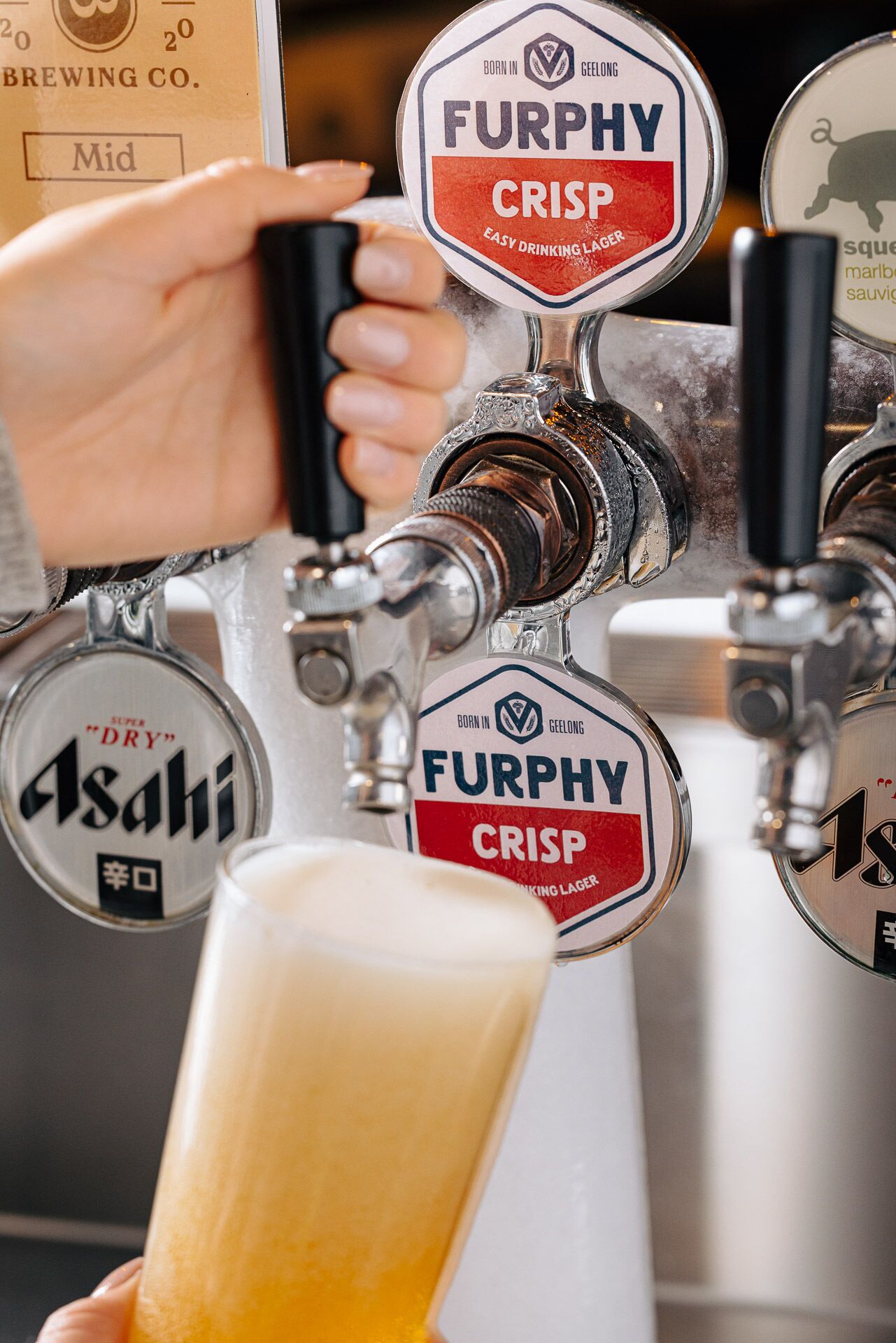 Hanefatt med skiltning for Asahi og Furphy Crisp øl.